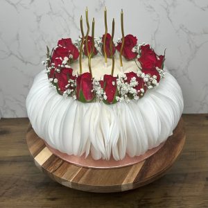 Luxury Large Cake: White cake with red roses, baby's breath & gold candles on wooden stand, set against marble.